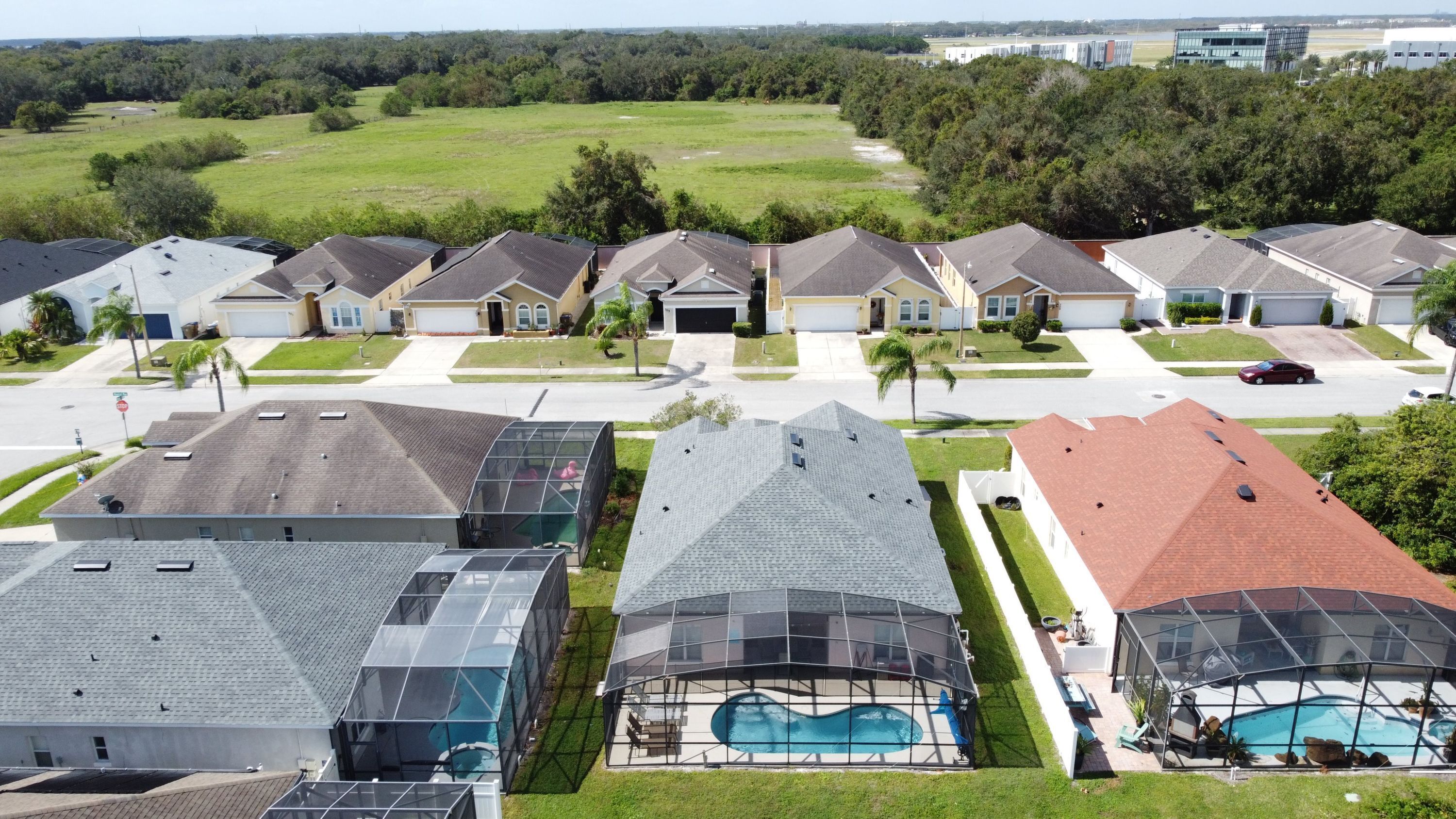 Un quartier résidentiel avec des maisons, une piscine et un ciel dégagé.