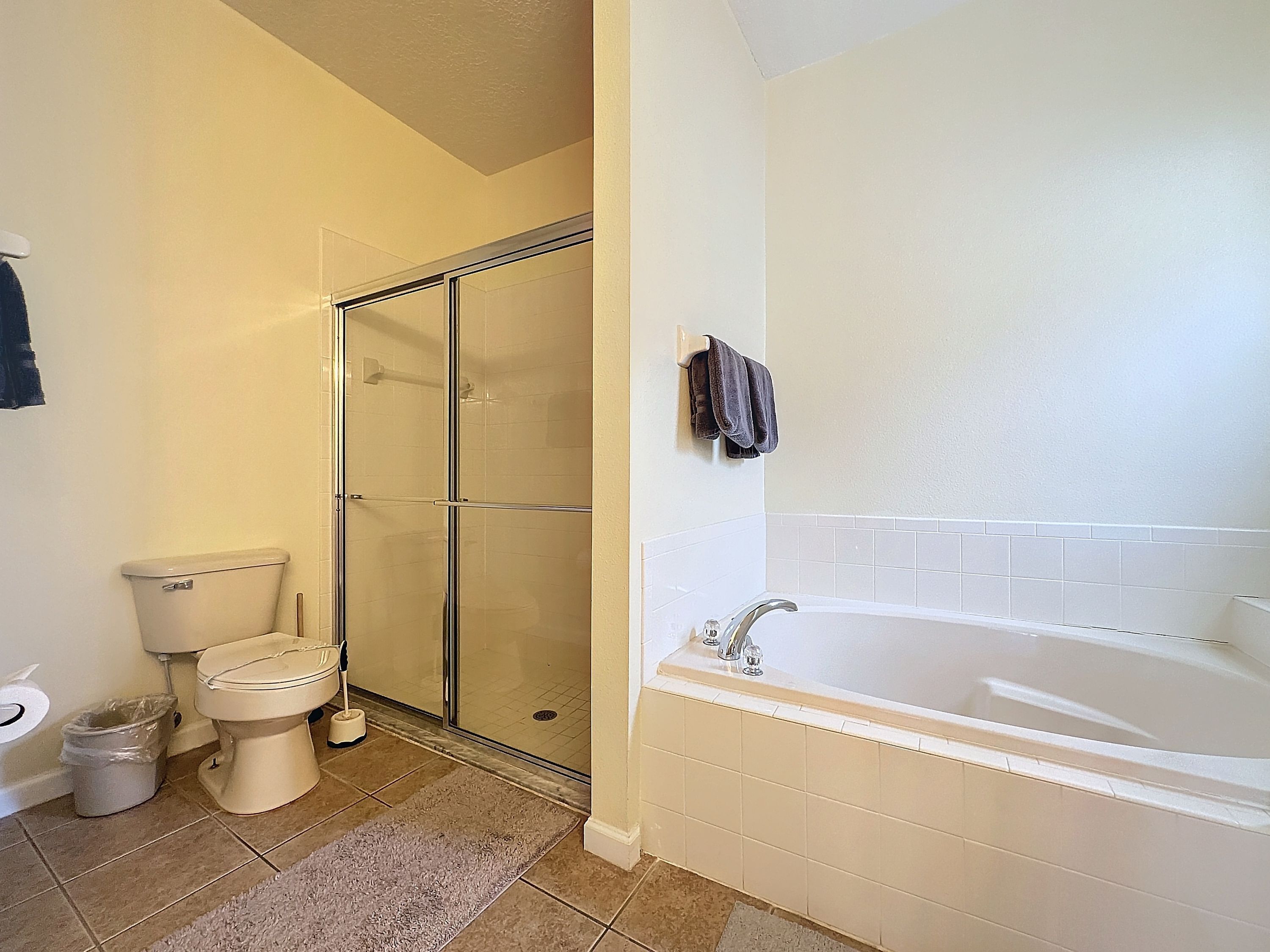 Une salle de bain comprenant des toilettes, une douche à parois de verre et une baignoire.