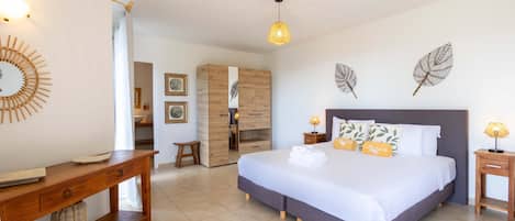 A bedroom with a bed, bedside tables, a desk, and a wardrobe.