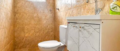 Un baño con inodoro, ducha y lavamanos.