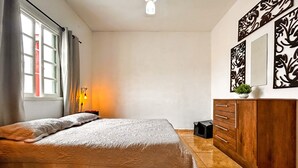 A bedroom with a bed, wooden dresser, and decorative wall art. - Tima Casa com Wifi pr Ximo a Praia em Itanha m SP (Itanhaém)