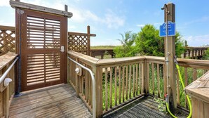 A wooden deck with a gate, a sign for showers, and a hose. - Carolina Beach Condo w/ Marina View, on Boardwalk (Carolina Beach)