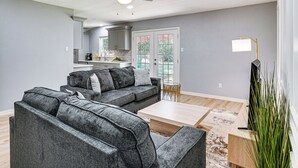 A modern living room with grey sofas, a coffee table, and a ceiling fan. - Family Home in Ft Worth Suburbs Near Benbrook Lake (Crowley)