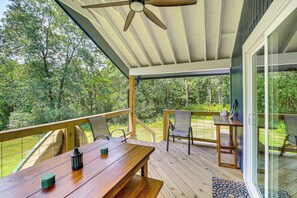 A wooden deck with a table and chairs, overlooking a wooded area. - Lake Hamilton Retreat w/ Kayaks & Spacious Yard! (Hot Springs)
