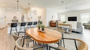 Ein modernes Wohnzimmer mit Essbereich, Küche und einer Sitzecke.