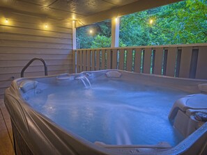 Un jacuzzi con cubierta de madera y vista a la vegetación.