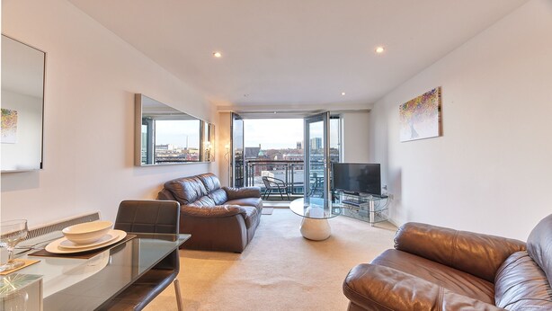 A modern living room with a leather sofa, a glass coffee table, and a TV on a stand. - Thornton in Newcastle Upon Tyne (Newcastle-upon-Tyne)