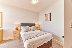 A neatly arranged bedroom with a bed, bedside lamps, a nightstand, and a wall-mounted artwork. - Low Friars in Newcastle Upon Tyne (Newcastle-upon-Tyne)