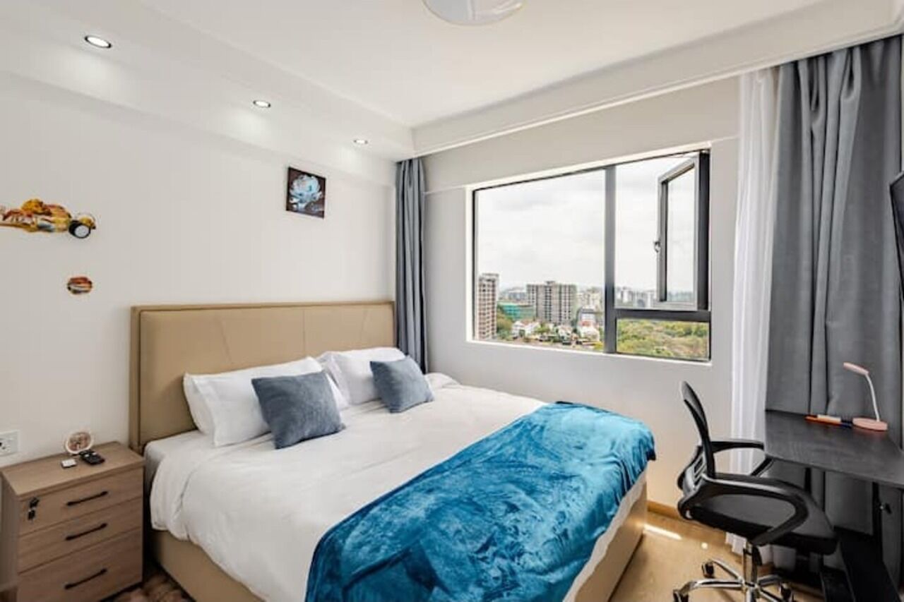 Una camera d'albergo moderna con un letto grande, una scrivania e vista sulla città.
