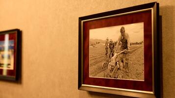 A framed photograph of a person operating a vintage tractor in a field.