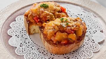 Two slices of toast topped with a savory mixture, placed on a lace doily.