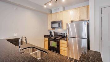 A modern kitchen with granite countertops, stainless steel appliances, and wooden cabinets.