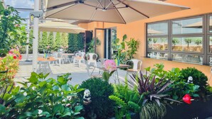 An outdoor seating area with umbrellas, chairs, and potted plants. - Dayin Serene Garden Hotel - Shanghai Hongqiao North Xinjing Metro Station (Shanghai)