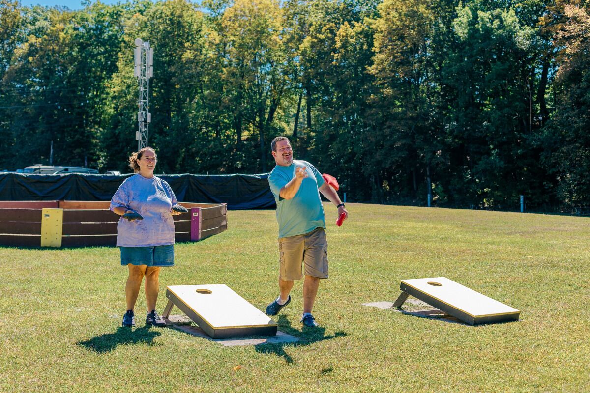 Two people playing a game outdoors with a goal post and a net.