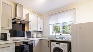 Eine kleine Küche mit Mikrowelle, Toaster, Spüle und Backofen.
