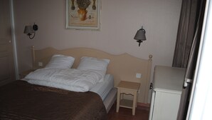 A hotel room with a large bed, a bedside table, a nightstand, a lamp, and a cabinet. - Apartment CLIMATISE 4 persons (les  issambres)