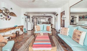 A spacious living room with a sofa set, a coffee table, and decorative items on the walls.