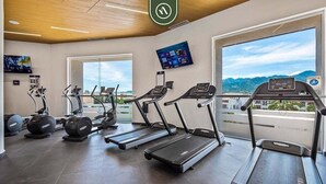 A gym with treadmills, elliptical machines, and weight stations.