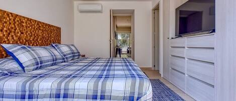 A bedroom with a bed, a TV, and a wardrobe.
