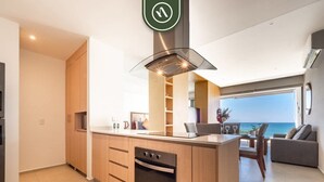 A modern kitchen with wooden cabinets, a built-in oven, and a glass range hood.