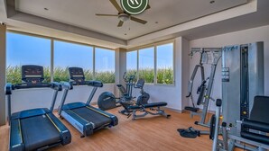 A gym with treadmills, elliptical machines, and weight equipment. - 2BR Condo with Rooftop Pool - 2 Min Walk to Beach (Bucerías)
