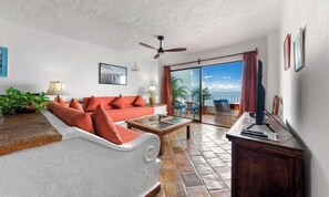 Ein Wohnzimmer mit einer Couch, einem Couchtisch und einem Deckenventilator.