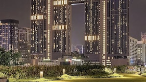 A high-rise building with illuminated windows and a prominent 'AXON' sign at the top. - Axon Residence by Emily in Town (Kuala Lumpur)