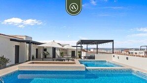 Ein Dachpool mit zwei Bereichen, Sitzgelegenheiten im Freien und einem überdachten Bereich mit Lichterketten.