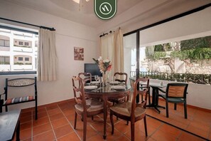 A dining area with a round table, chairs, and a TV.