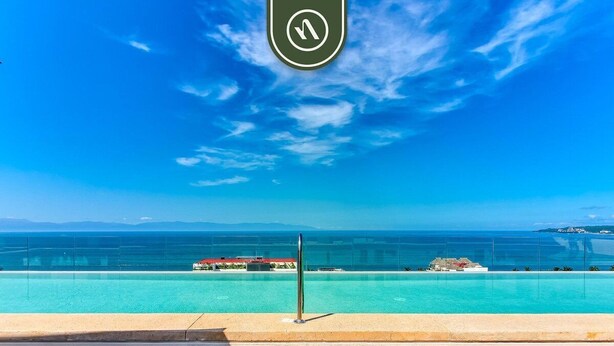 A wooden staircase leading to a pool with a clear view of the ocean and distant islands. - New 1 BR Condo with Amazing Rooftop Pool - Jacuzzi (Bucerías)