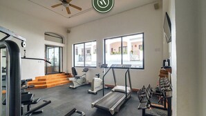 A gym with treadmills, elliptical machines, and weight benches.