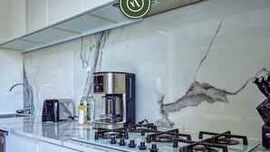 Una cocina moderna con estufa a gas, cafetera y tostadora.