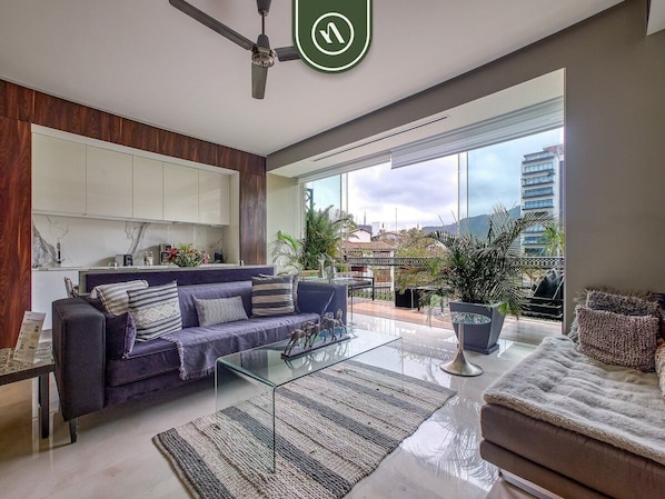 Ein modernes Wohnzimmer mit einer Couch, einem Couchtisch und Blick auf die Stadt.