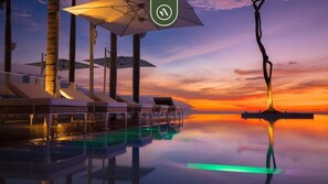 A serene sunset pool area with lounge chairs and umbrellas, reflecting the sky. - Pier 57 511 | 1BR/2BA Puerto Vallarta | Pool, Gym (Puerto Vallarta)