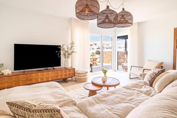 A modern living room with a flat-screen TV, a wooden cabinet, a round coffee table, and a large sofa. - Casa La Cala De Mijas With Pool for 8 (Mijas)