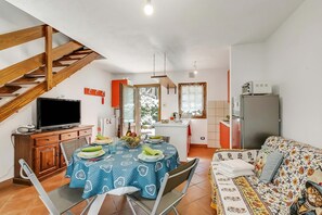 A compact living space with a dining area, kitchenette, and a sofa. - La Casa Di Dada With Terrace and Garden (Oulx)
