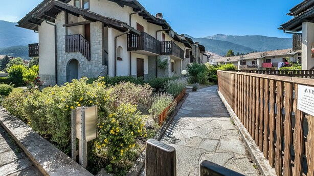 A traditional building with a stone facade, wooden balconies, and a stone pathway. - La Casa Di Dada With Terrace and Garden (Oulx)