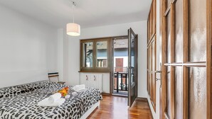 A bedroom with a bed, a window, a radiator, and a door leading to a balcony. - La Casa Di Dada With Terrace and Garden (Oulx)