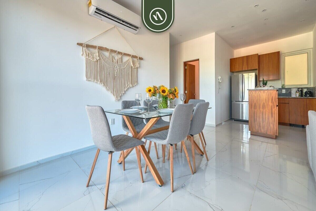 Una cocina moderna con armarios de madera y un refrigerador de acero inoxidable.