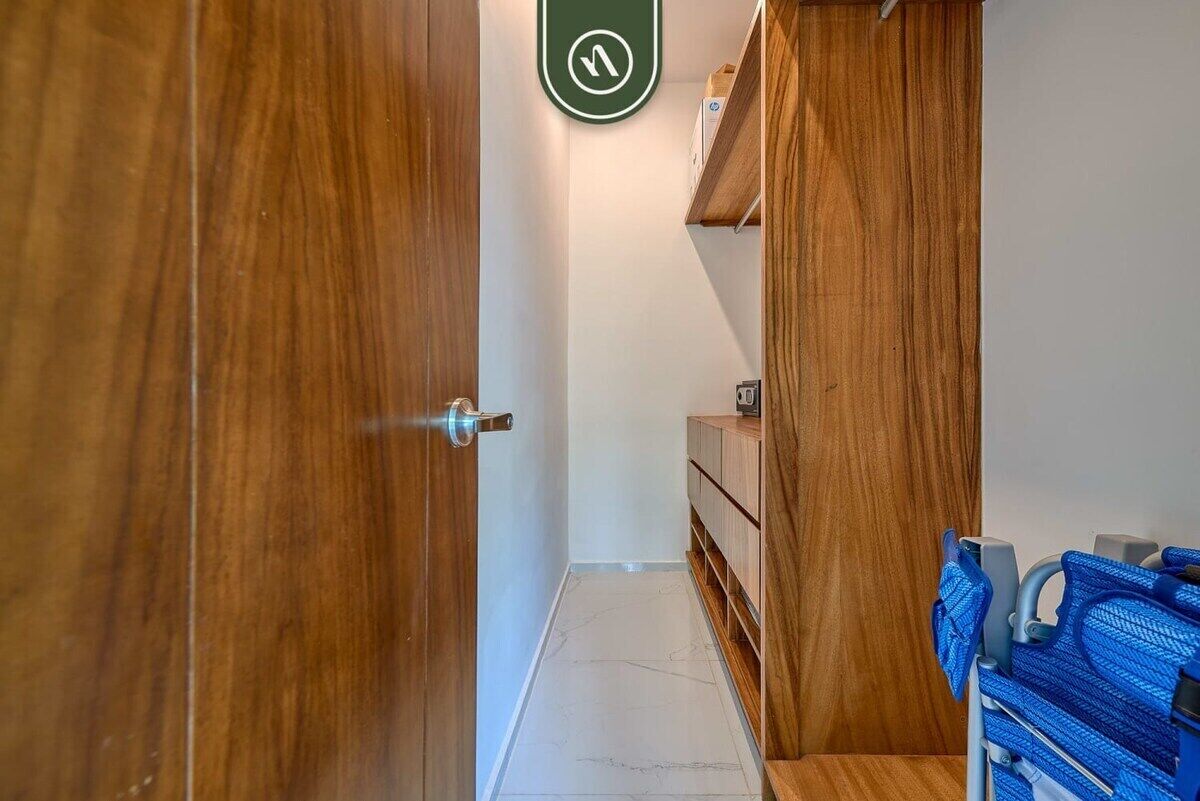 Un pasillo con puertas de madera, un armario y una silla azul.
