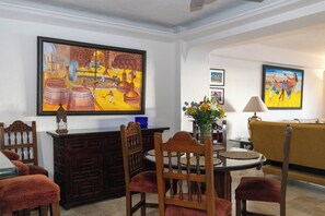 A dining area with a round table, chairs, and a vase with flowers.