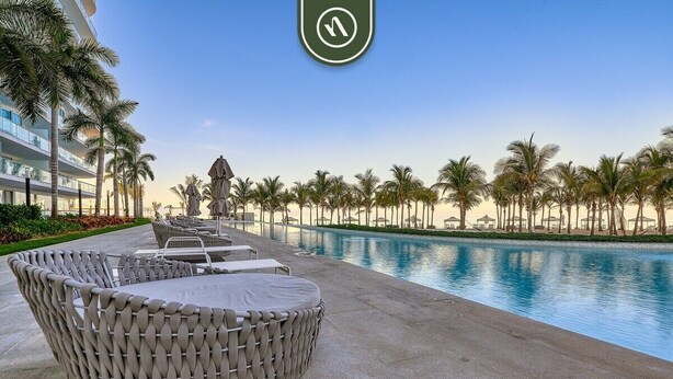 A poolside area with lounge chairs and a view of the pool.