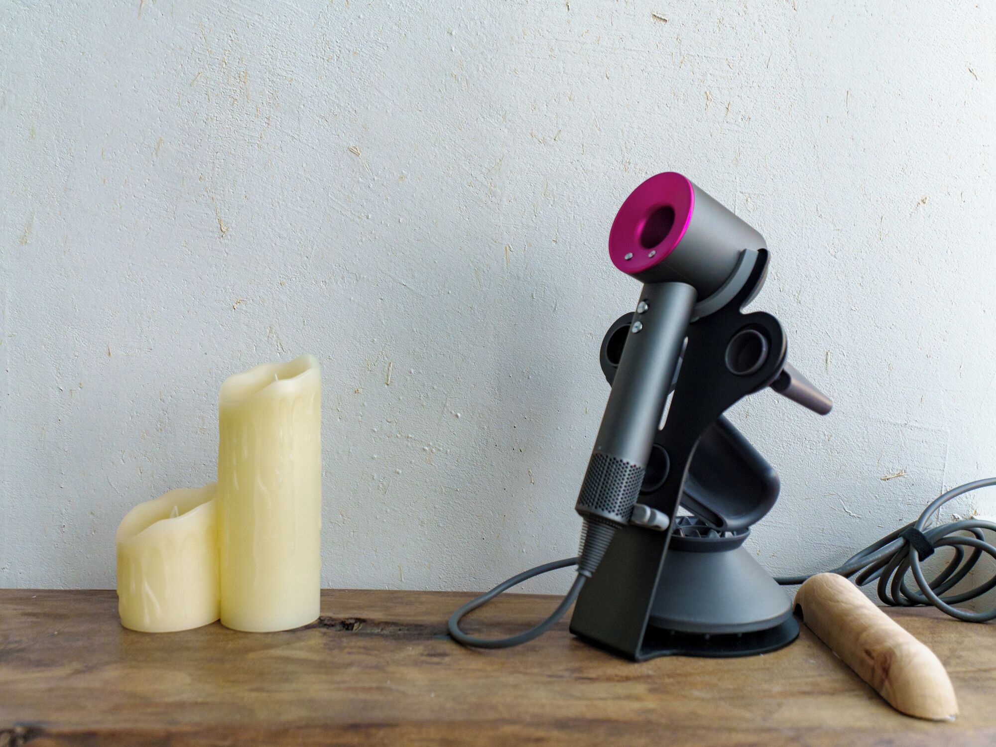 Ein Mikrofon auf einer Holztischplatte, mit einem Kabel und einem Holzgegenstand daneben.