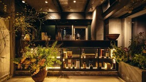 A modern interior with a wooden floor, a large potted plant, and a wine rack with bottles. - M Panda Tower Boutique Hotel (Chengdu)