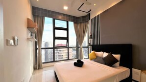 A modern bedroom with a large bed, a ceiling fan, and a city view through large windows. - The Robertson Residences Free Gym & Pool (Kuala Lumpur)