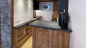 A modern kitchen with a wooden countertop, stone wall, and a round mirror. - New Le Corbier for 10 p. Renovated top-of-the-range 4bed/2bath/2wc/slope frontage (Villarembert)