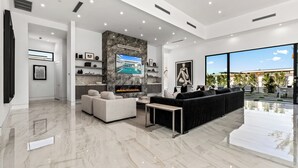 Un salon moderne avec une cheminée, des canapés et un téléviseur.