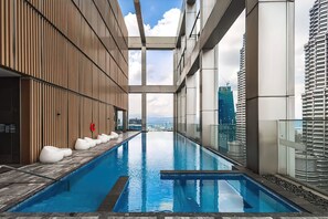 A modern indoor swimming pool with a clear view of the city skyline. - Tropicana The Residences KLCC Skypool (Kuala Lumpur)