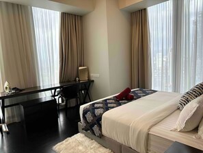 A hotel room with a bed, a desk, and a chair. - Tropicana The Residences KLCC Skypool (Kuala Lumpur)