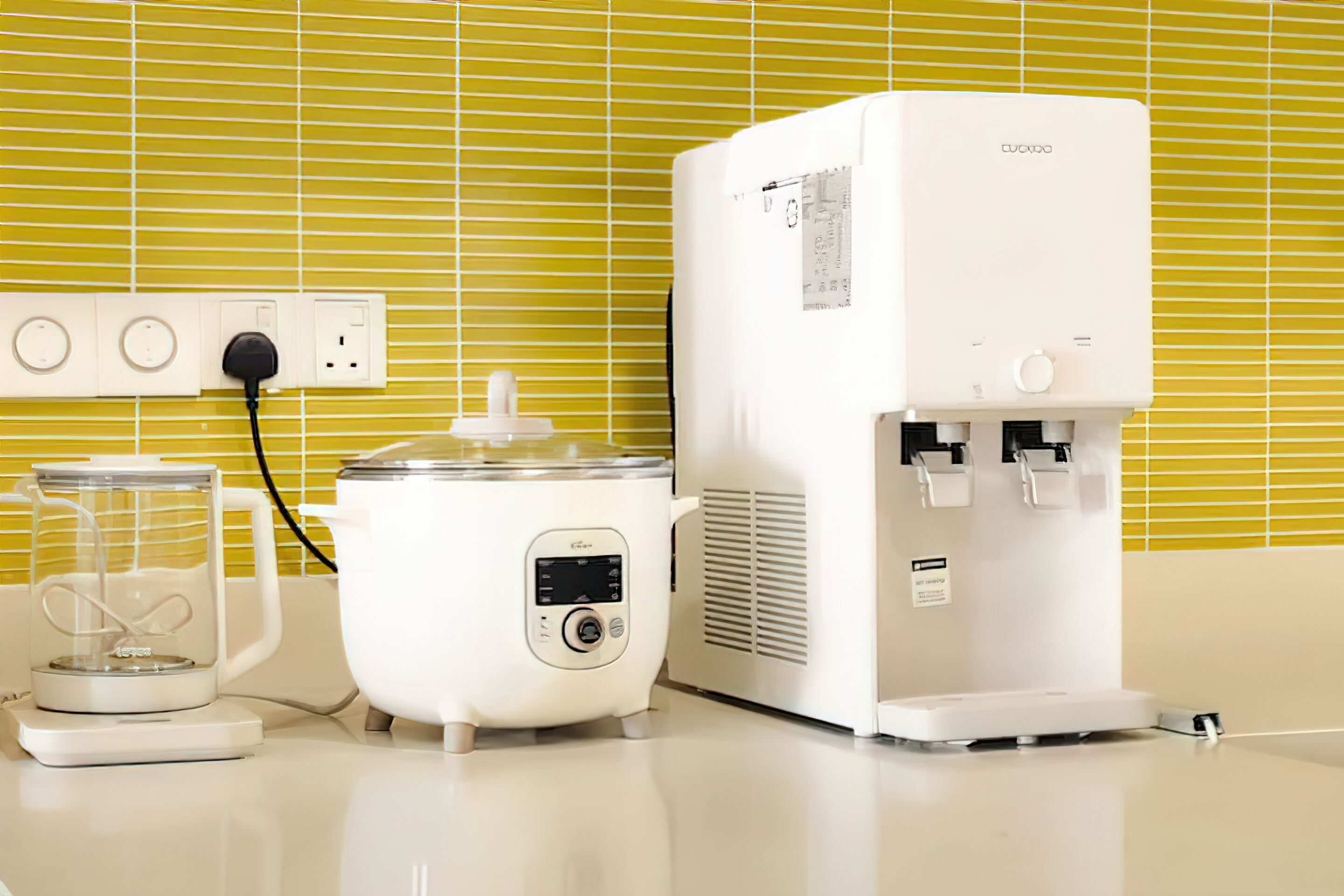A kitchen with a coffee maker, a scale, and a water dispenser.